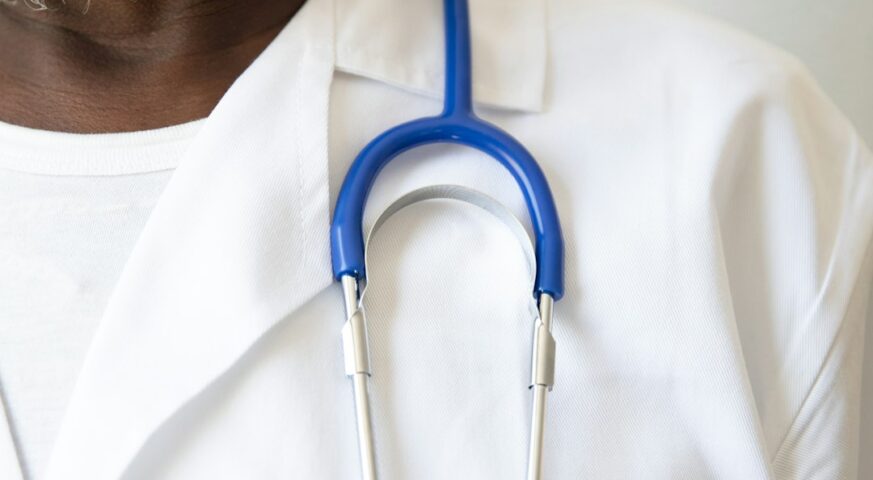 Black male doctor with a stethoscope in a clinical setting